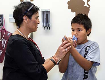 Boy using spacer and inhaler