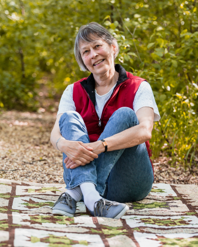 Donna sitting on one of her quilts