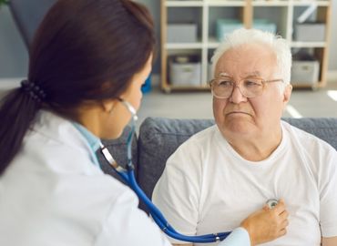 Doctor listening to man's chest