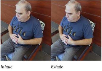 man sitting in chair inhaling and exhaling with a deep breath from diaphram