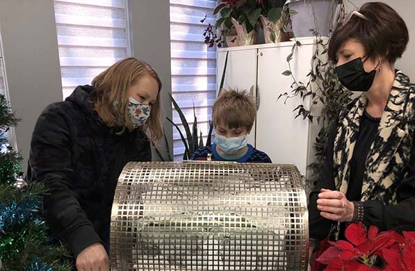 Erin, Reid, and Josie at a draw drum wearing masks