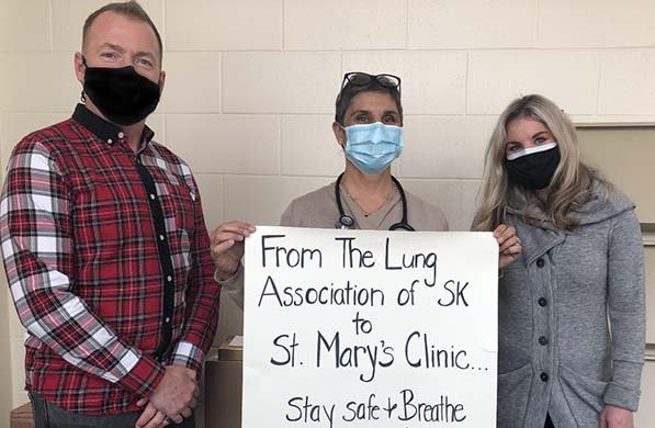 Trent, Jill, and Dr. Mehtar holding up a sign saying thank you