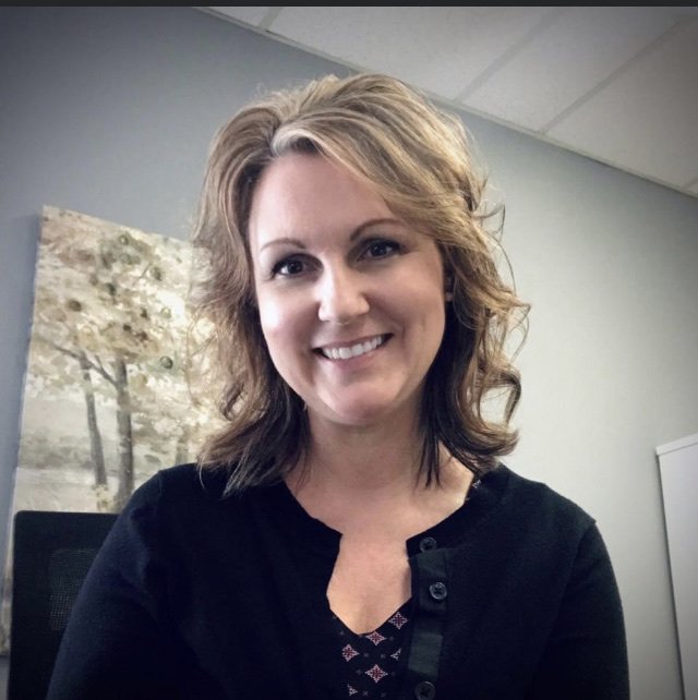 Lori smiling at the camera in her office