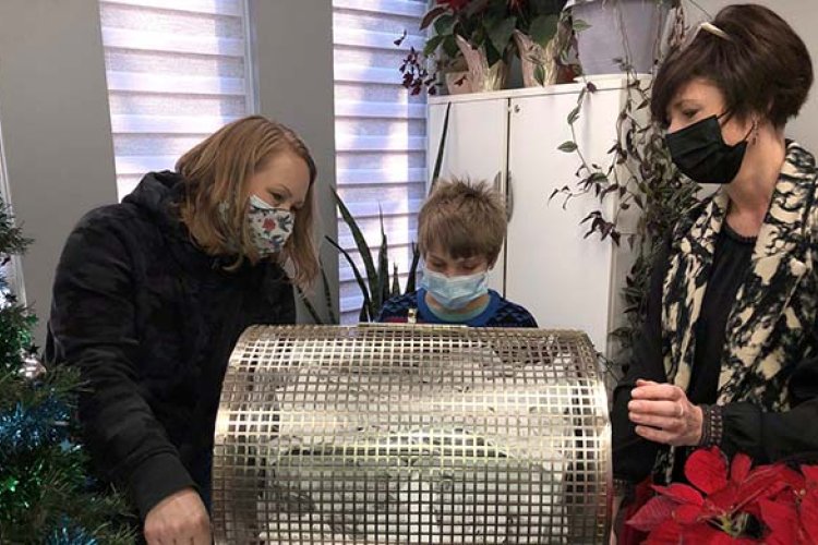 Erin, Reid, and Josie at a draw drum wearing masks