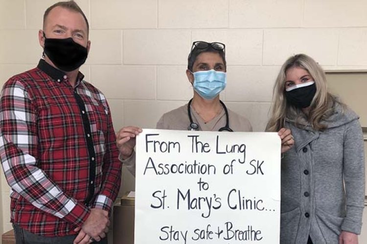 Trent, Jill, and Dr. Mehtar holding up a sign saying thank you