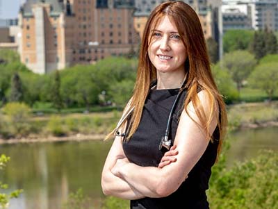 Dr. Marcoux standing infront of a river with her arms crossed