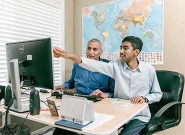 Dr, Ramlall and his son sitting at a computer